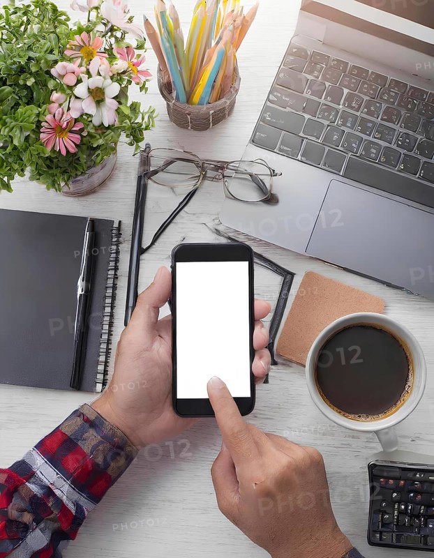 A person is using a cell phone on a desk with a laptop and a cup of coffee. The desk is cluttered with various items such as pens, pencils, and a calculator. Concept of productivity and focus, AI generated