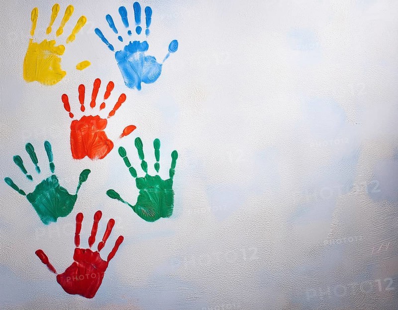 Brightly colored handprints in various hues arranged artistically on a textured white surface, evoking creativity, fun, and the spirit of collaboration or children's artistry, AI generated