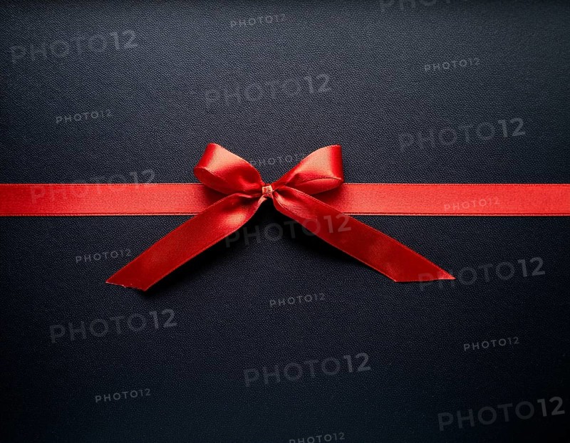 A beautifully wrapped gift box adorned with red satin ribbons forming a bow, contrasting against a linear textured surface, evoking feelings of celebration and elegance, AI generated