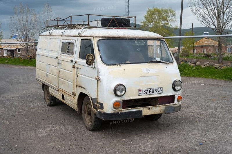 An old white van parked on the side of the road in a rural area, rust decoration visible, van, JerAZ-762 or ErAZ-762, Armenia