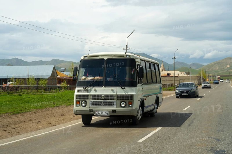 A bus travelling on a road along a rural and mountainous landscape with a cloudy sky, PAZ-3205 Bus, Armenia