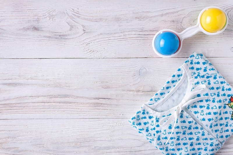 Things for a newborn on a white wooden background