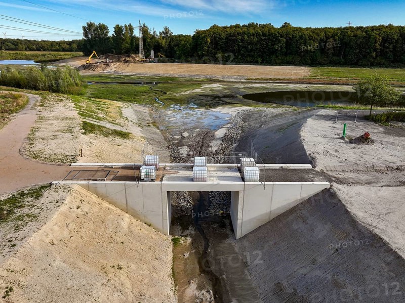 Dortmund, Castrop-Rauxel, North Rhine-Westphalia, Germany - River renaturalisation, renaturation of the Emscher, flood retention basin HRB Mengede. Heimanngraben intake in front, construction of a bridge over the ditch. A new floodplain landscape is being created at the Emscher-Auen farm, expansion of the area for flood protection during heavy rainfall and for biodiversity. The previously straightened Emscher is given curves again and can meander through its new floodplain. Following the construction of a parallel sewer, the Emscher has been completely free of sewage since 2022. The river was previously an open, above-ground combined sewer with rainwater and wastewater