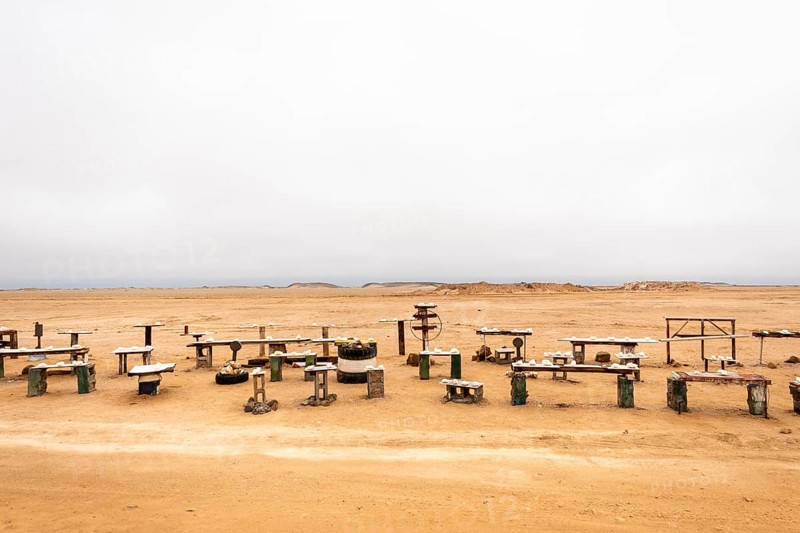Pink salt displayed on wooden stands along the road to Namib-Naukluft National Park and Sandwich Harbour, Namibia, set against a desert landscape