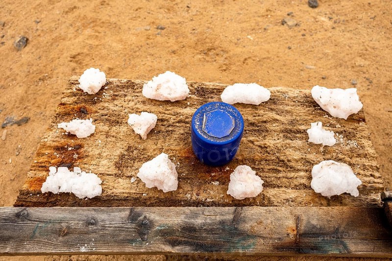 Pink salt displayed on wooden stands along the road to Namib-Naukluft National Park and Sandwich Harbour, Namibia, set against a desert landscape