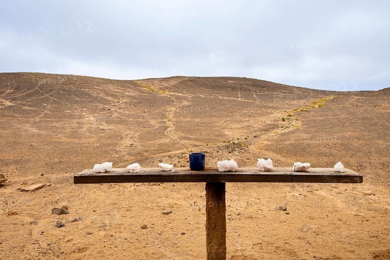 Pink salt displayed on wooden stands along the road to Namib-Naukluft National Park and Sandwich Harbour, Namibia, set against a desert landscape