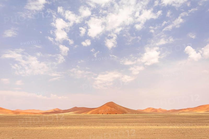 Sossusvlei in Namibia is a desert wonder, famous for its giant red dunes, glowing at sunrise and sunset, and its hauntingly beautiful dead tree valleys