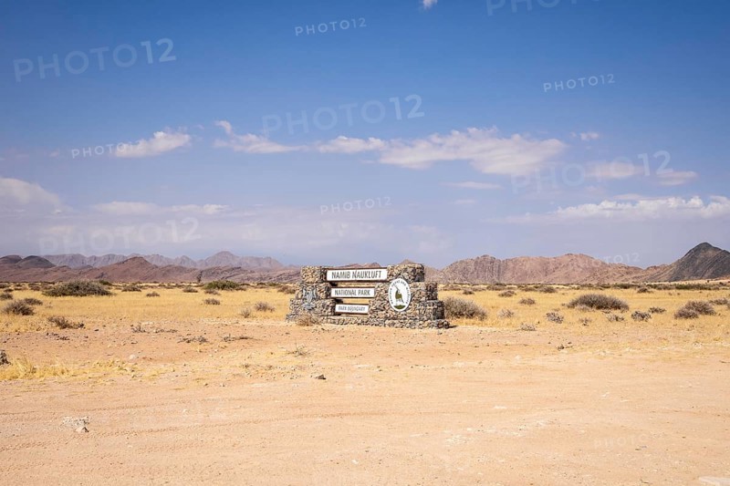 Stone entrance sign of Namib-Naukluft National Park in Namibia- 27 August, 2025: surrounded by desert plains and distant mountain ranges
