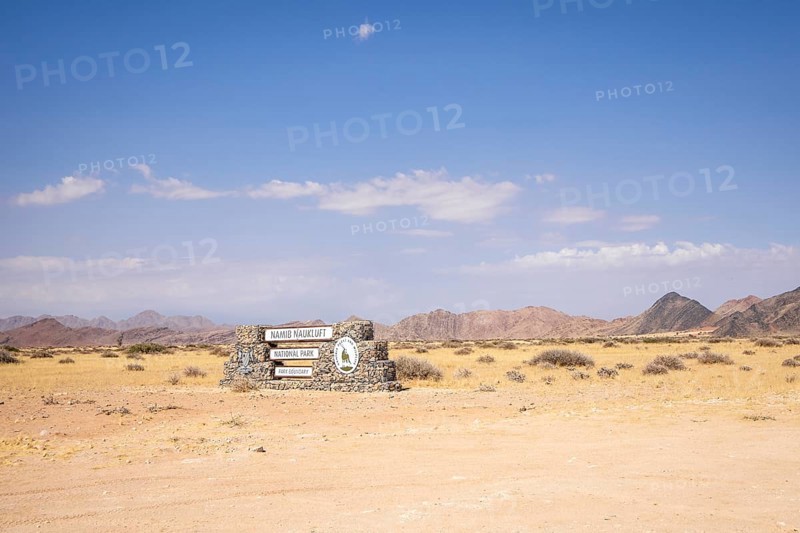 Stone entrance sign of Namib-Naukluft National Park in Namibia- 27 August, 2025: surrounded by desert plains and distant mountain ranges