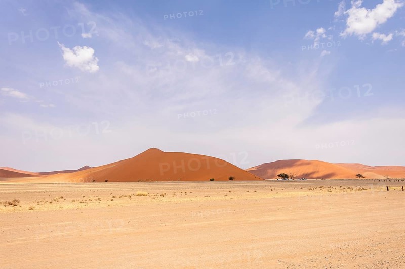 Sossusvlei in Namibia is a desert wonder, famous for its giant red dunes, glowing at sunrise and sunset, and its hauntingly beautiful dead tree valleys