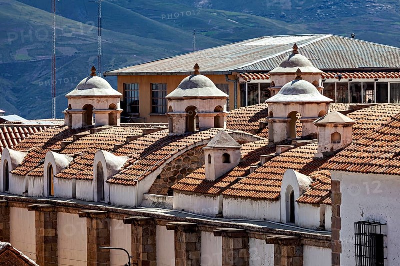 Close-up of building roofs with characteristic small domes and mountain scenery in the background, The churches of the city of Potosi in Bolivia