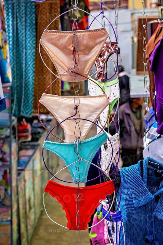Colourful underwear hanging on chains in a lively market shop, selling women's panties in the market halls of Potosi Bolivia