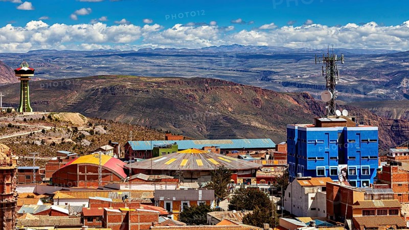 View over a city with colourful roofs and a telecommunications tower, surrounded by mountains under a blue sky, view over the city of Potosi in Bolivia