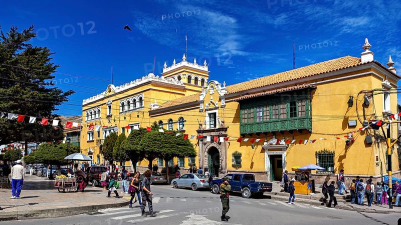 Colonial-style building with market scene and decorative flags, The streets of the historic centre of Potosi in Bolivia