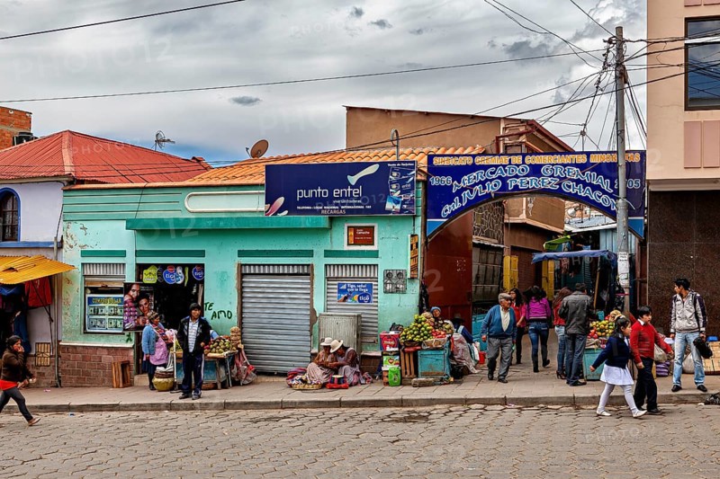 Entrance to a market with fruit stalls and passers-by, people in the streets of Potosi in Bolivia