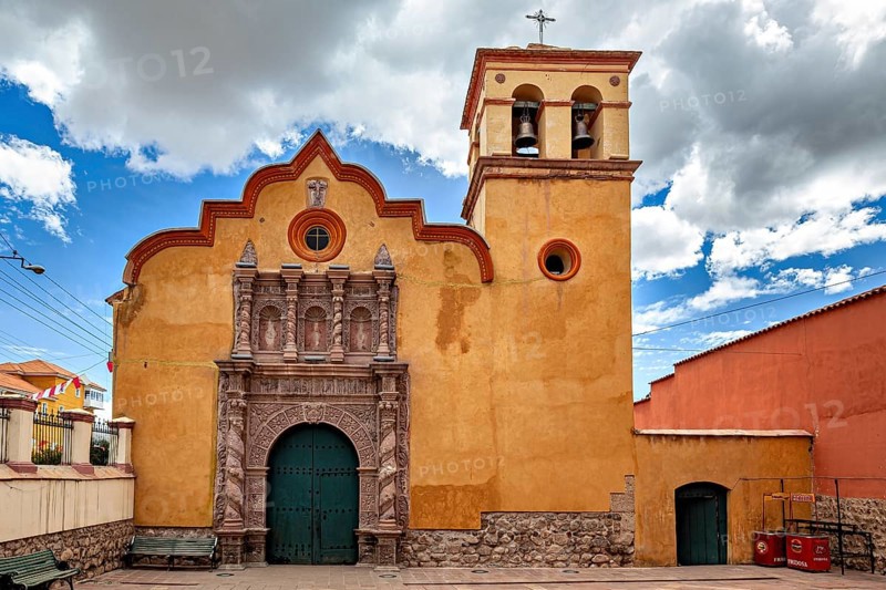 Colonial church with baroque bell tower and impressive wooden gate under a dramatic sky, The old churches of Potosi in Bolivia