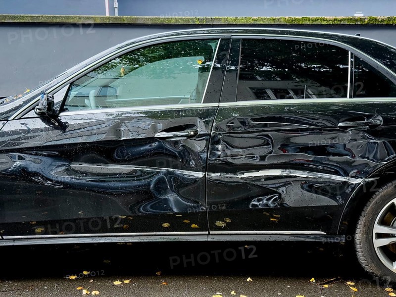 Dented car door after traffic accident, significant bodywork damage to a car in Wuppertal, Germany