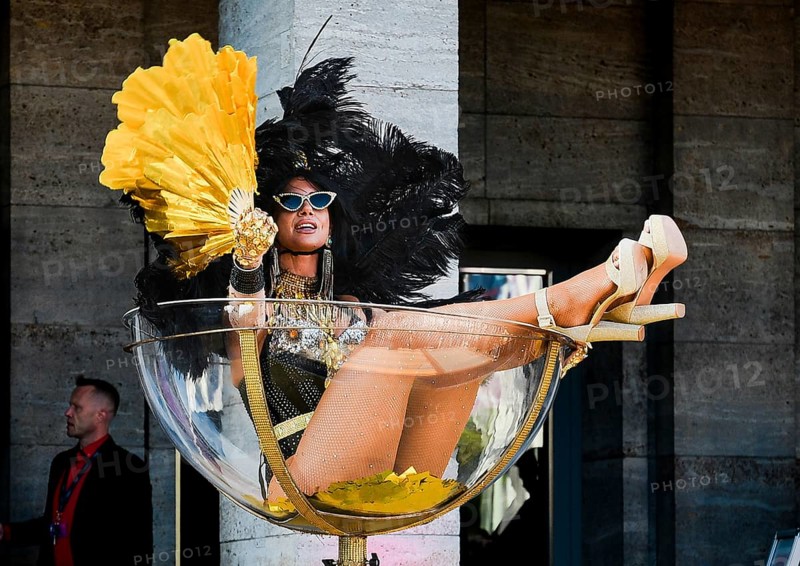 An erotic model sits in an oversized champagne glass at the Grand Opening of the Venus Erotic Fair in Berlin