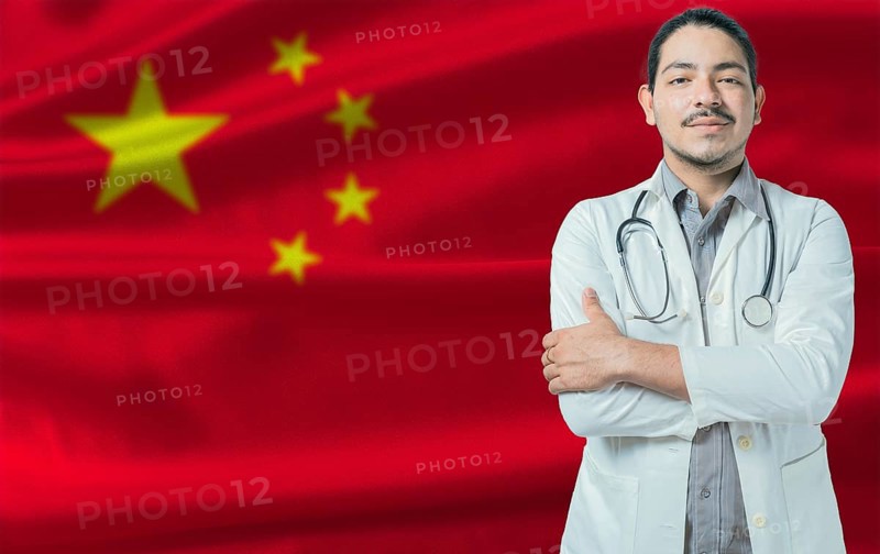 Male doctor on China flag. Doctor with crossed arms on China flag. China Health and Care concept