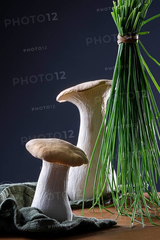 oyster mushrooms with chives against a dark background