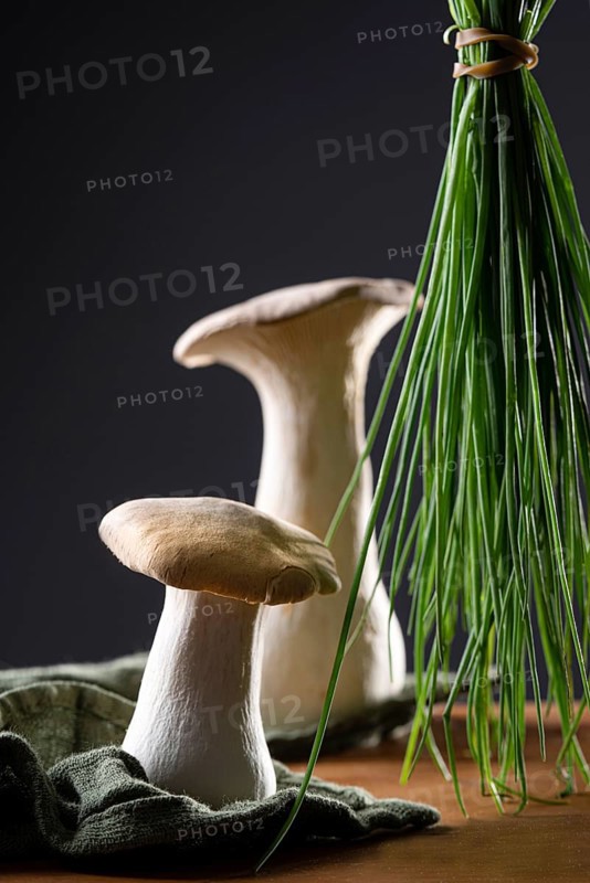 oyster mushrooms with chives against a dark background