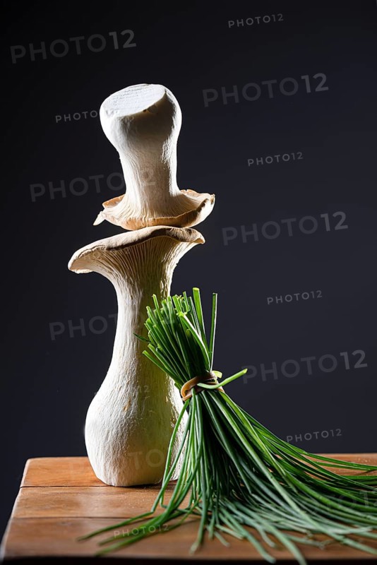 oyster mushrooms with chives against a dark background