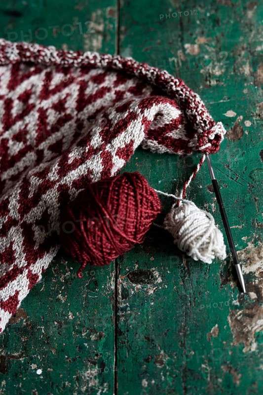 Knitted piece with ball of wool and knitting needle
