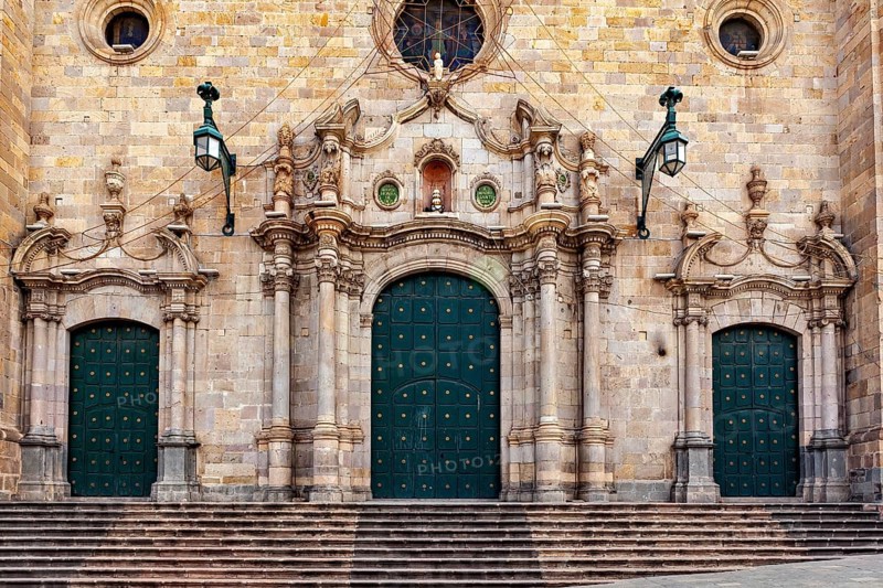 Monumental façade with three green double doors and complex decorations, impressive symmetry, The churches in Potosi in Bolivia