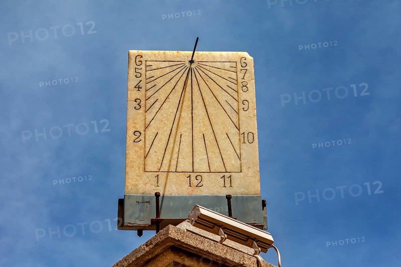 Classic stone sundial with clear dial and hands against a sunny background, The sundial of Potosi in Bolivia