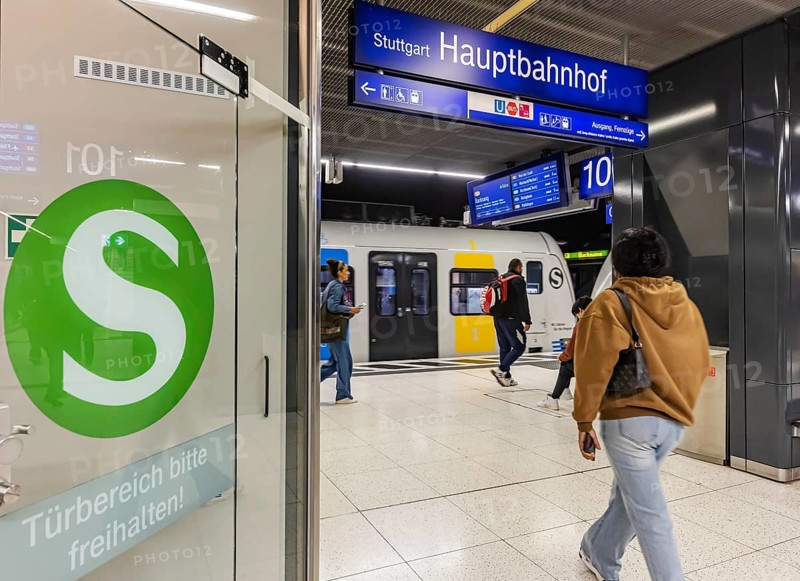 S-Bahn arriving underground at the main station stop. Platform with travellers and logo. Stuttgart, Baden-Württemberg, Germany