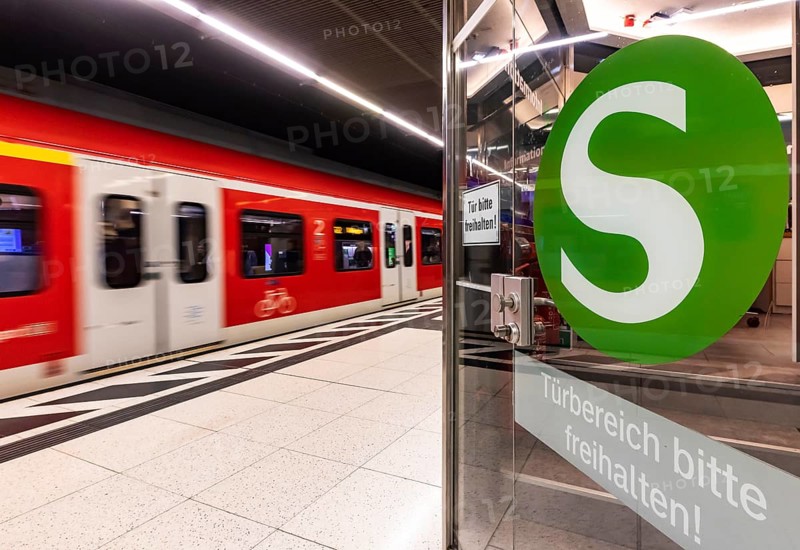 S-Bahn arriving underground at the main station stop. Platform with travellers and logo. Stuttgart, Baden-Württemberg, Germany
