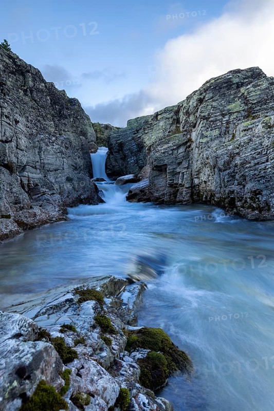A river flows through a narrow gorge, over a small waterfall, surrounded by steep cliffs, Peer Gynt hytta, Rondane National Park, Otta, Innlandet, Norway