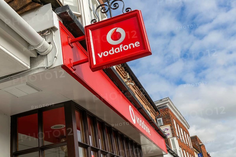 Vodafone sign with logo on shopfront of Vodafone phone shop, Marlborough, Wiltshire, England, UK