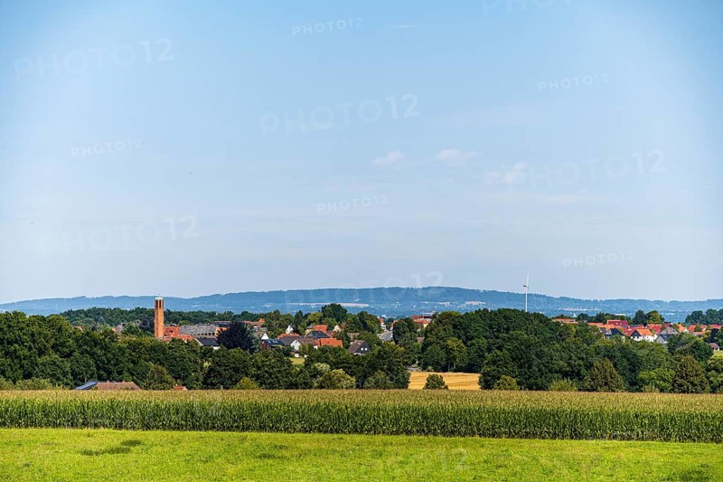 A rural view of a village surrounded by fields and trees under a blue sky, Bielefeld, Westphalia, North Rhine-Westphalia