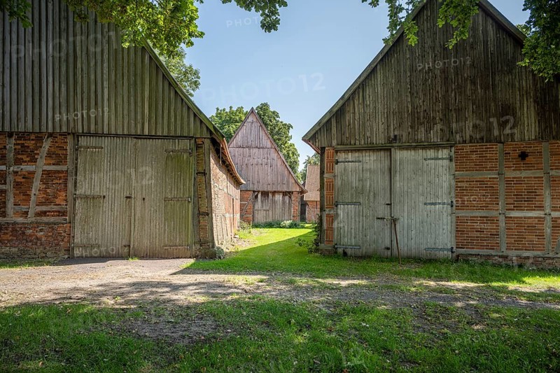 Ancient half-timbered houses with wooden and brick façades in the shade, Weser cycle path, Schlüsselburg barn quarter, Petershagen, North Rhine-Westphalia