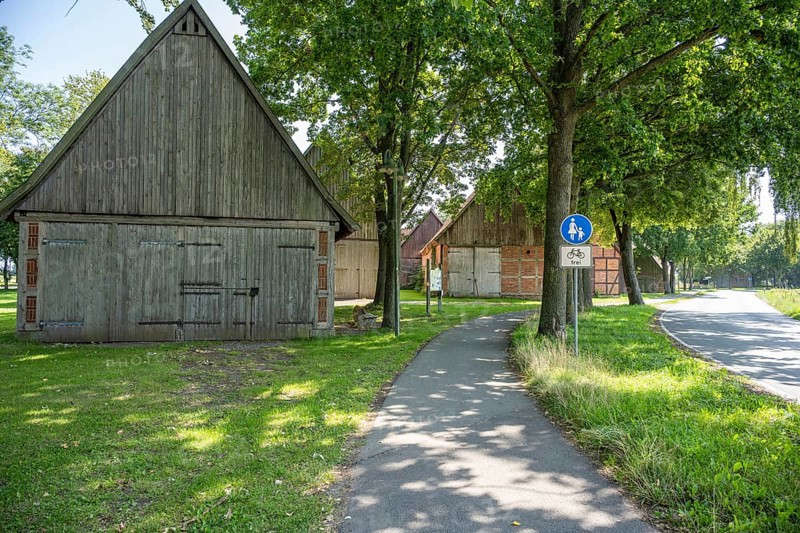 Half-timbered houses next to a cycle path surrounded by green meadows and trees, Weser cycle path, Scheunenviertel Schlüsselburg, Petershagen, North Rhine-Westphalia