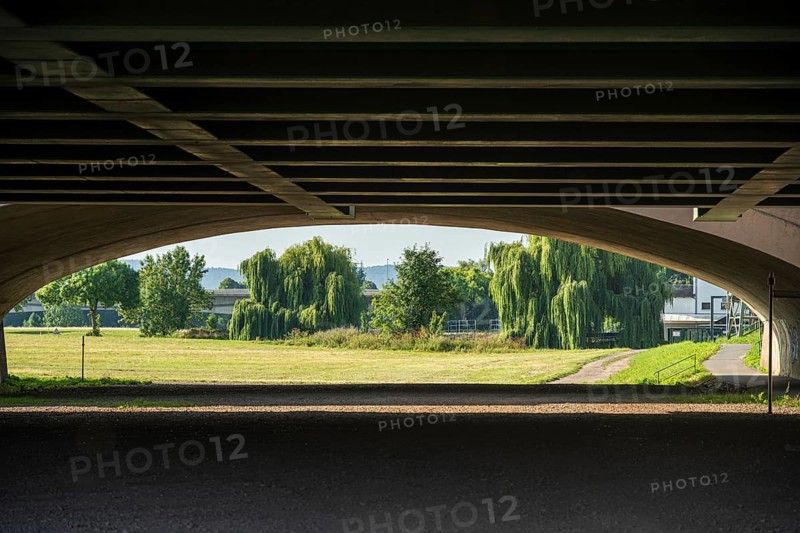 View under a bridge onto a summer landscape with willow trees, Minden waterway junction, Minden-Lübbecke, North Rhine-Westphalia