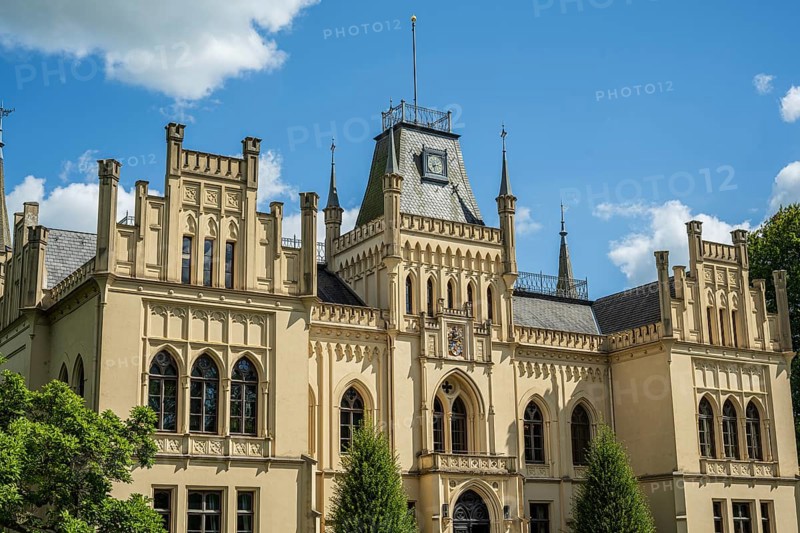 An imposing castle with Gothic elements and large windows under a blue sky, Schloss Evenburg, Leer, East Frisia