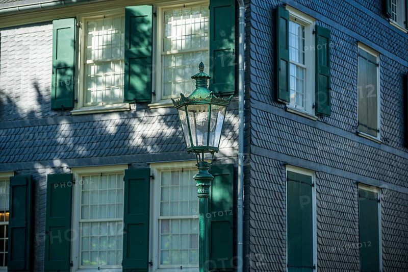 Side view of a building with green shutters, old lantern and shadow play, Friedrich Engels House in Wuppertal Barmen