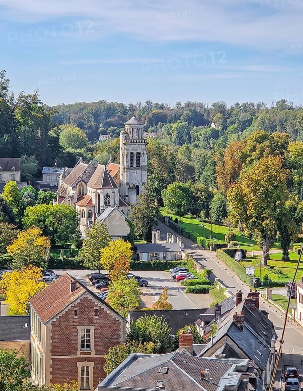 High-angle view of the charming town of Pierrefonds with view to the historic Eglise Saint-Sulpice. Vibrant autumn foliage conveying a quiet, picturesque cityscape atmosphere