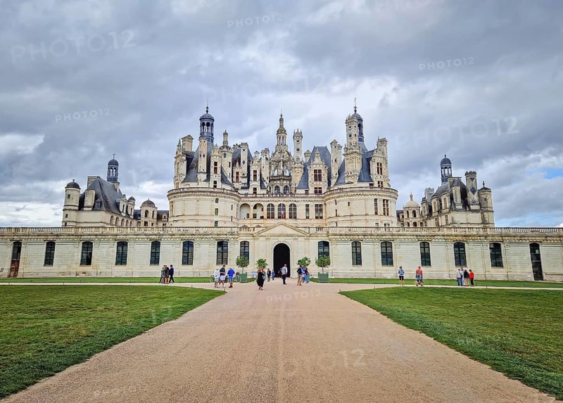 Chambord, Loir-et-Cher, France - August 30, 2023 Chateau de Chambord, a majestic medieval castle with green gardens. Iconic French Renaissance architecture palace, under a dramatic, cloudy sky