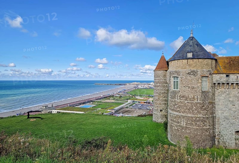 Chateau de Dieppe, a historic fortress perched on a cliff overlooking the turquoise waters of the English Channel. The stone castle with pointed towers has view to the town and a long pebble beach