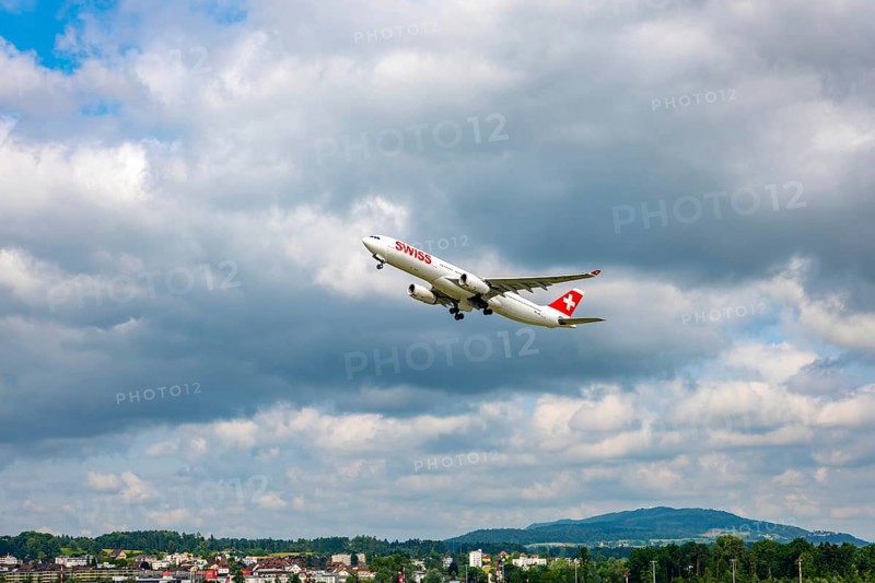 Swiss Airlines Passenger Airplane Take Off From the Runway and Flying Against Blue Sky and Clouds in a Sunny Summer Day From the Airport in Kloten, Zurich, Zurich Canton, Switzerland