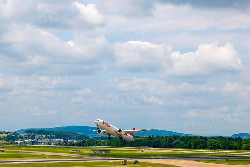 Swiss Airlines Passenger Airplane Take Off From the Runway and Flying Against Blue Sky and Clouds in a Sunny Summer Day From the Airport in Kloten, Zurich, Zurich Canton, Switzerland