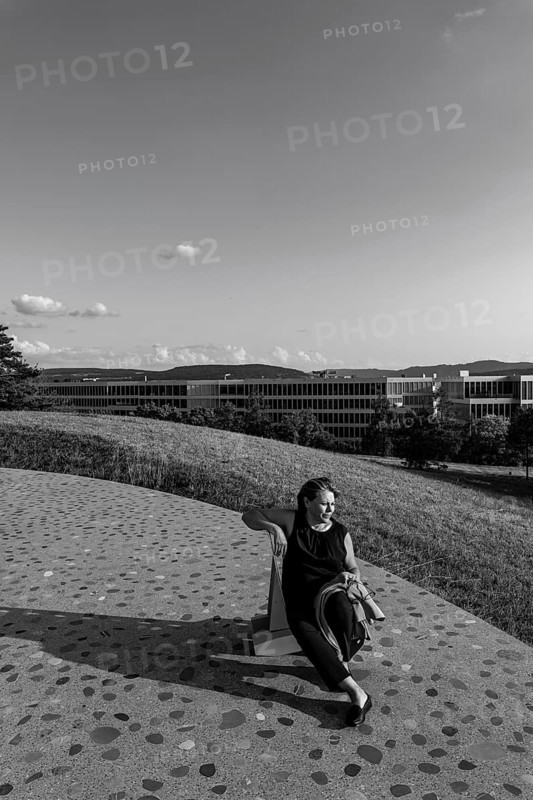 Nature Park with Panoramic View and Modern Building and a Woman Sitting on a Chair in a Sunny Summer Day in Circle, Kloten, Zurich, Zurich Canton, Switzerland