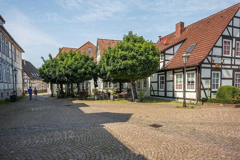 Paved courtyard with traditional half-timbered houses and trees. Historic and peaceful atmosphere, Verden an der Aller, Lower Saxony, Germany