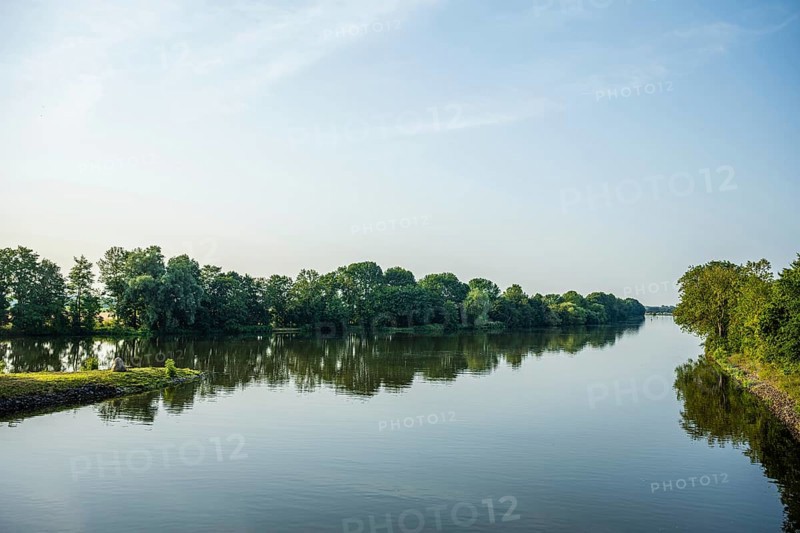 A calm river with green trees and blue sky, peaceful landscape, Weser cycle path, Nienburg Weser district, Balge, Lower Saxony, Germany