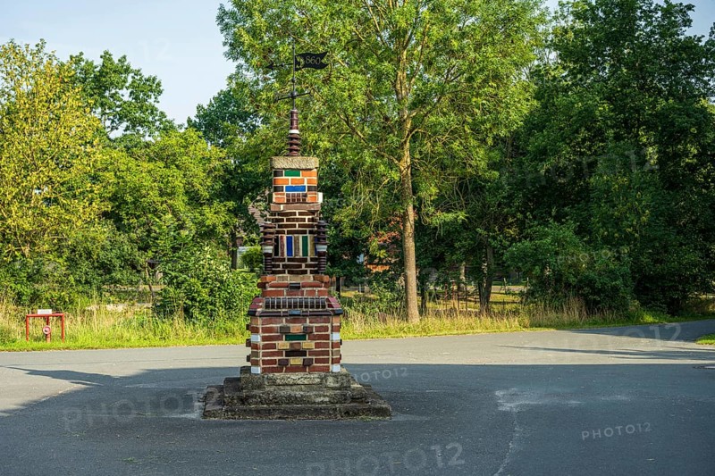 Colourful brick sculpture in a park with green trees in the background in the afternoon, Bücken, district of Nienburg Weser, Lower Saxony