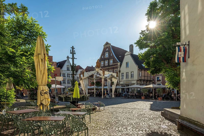 Charming square with half-timbered houses and parasols under a bright blue sky, Warendorf, Münsterland, North Rhine-Westphalia