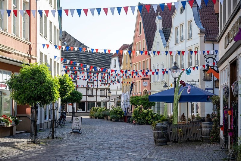 Colourfully decorated street in an old town with garlands and plants along the pavements, Warendorf, Münsterland, North Rhine-Westphalia
